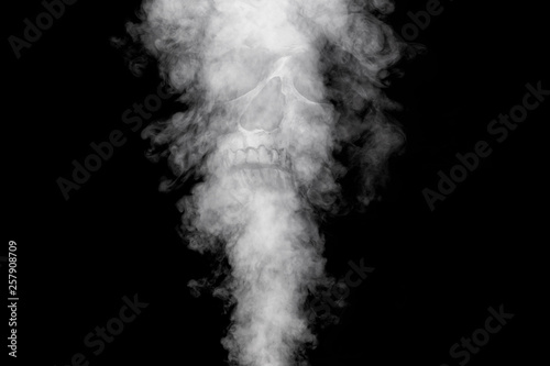 Curls or a column of smoke rising from something unseen against a black background. Skull appears in smoke. 