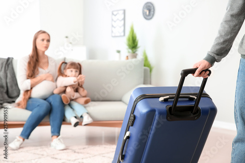 Man with suitcase leaving h...