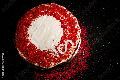 Beautiful home made red velvet cake decorated with whipped cream and raspberry crumbs. Celebrating 100th anniversary or 100th birthday for person or company, corporation. 