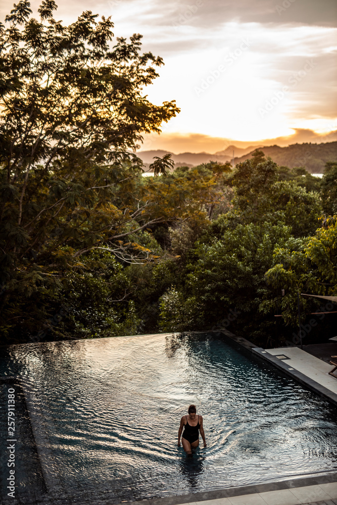 Philippines, Palawan, Coron, woman in swimming pool in the evening Philippines, Palawan, Coron, woman in swimming pool in the evening