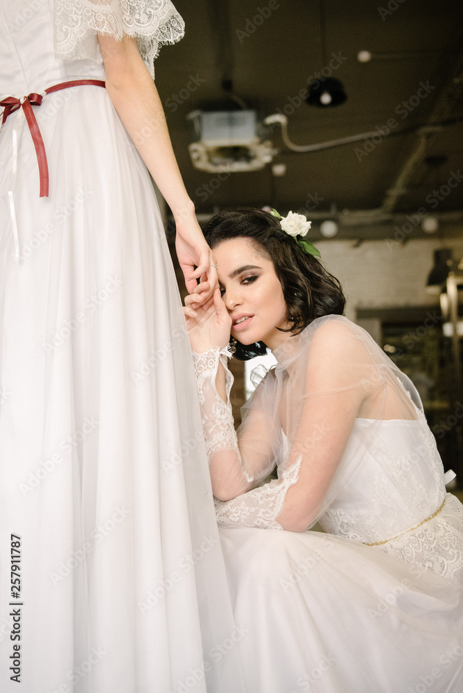 Naklejka premium Girls in white wedding dresses are posing. Advertising of wedding dresses