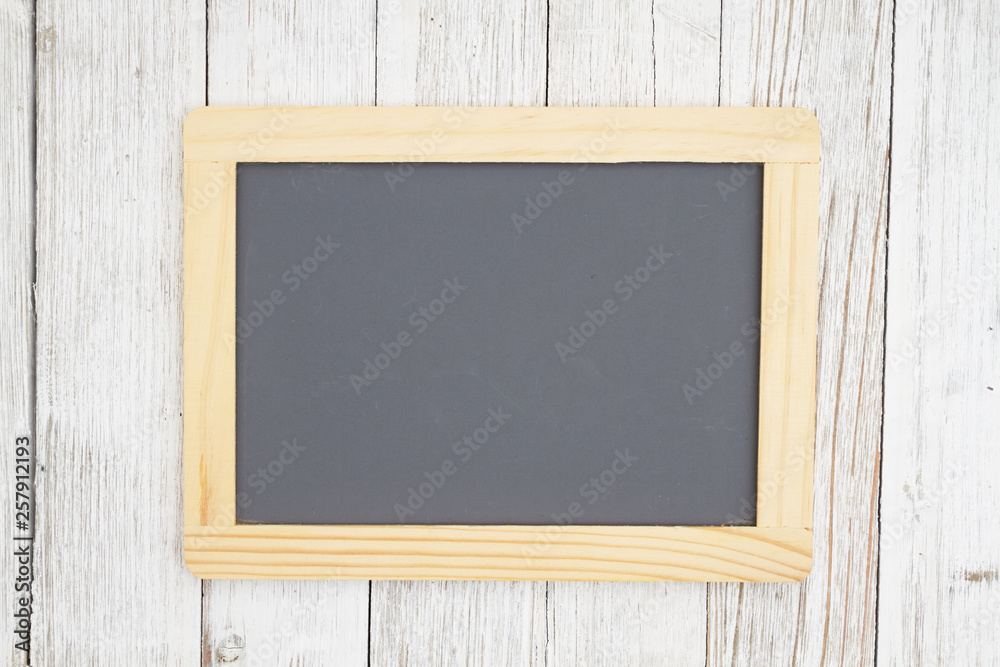 Blank chalkboard on weathered whitewash textured wood background Blank chalkboard on weathered whitewash textured wood background