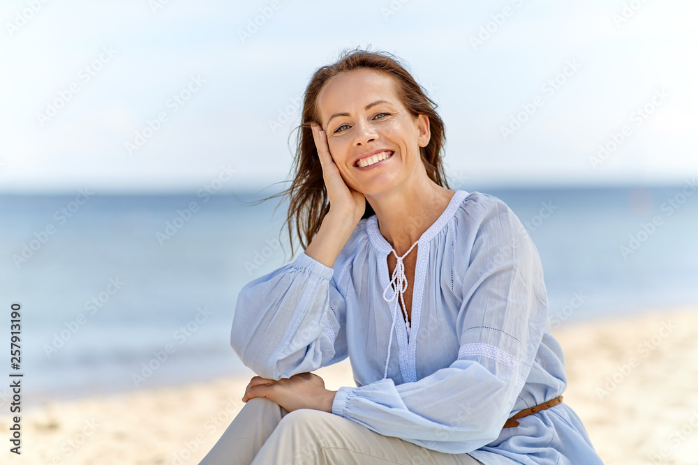people and leisure concept - happy smiling woman on summer beach