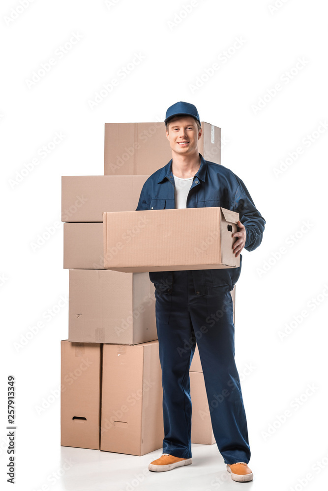 handsome mover in uniform carrying cardboard box and looking at camera isolated on white handsome mover in uniform carrying cardboard box and looking at camera isolated on white