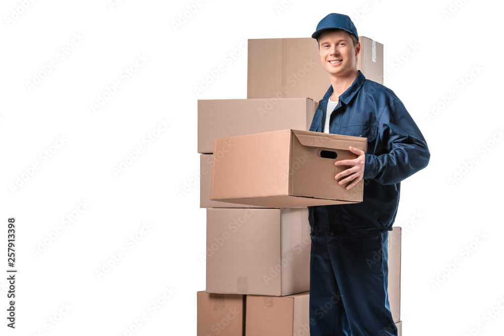 handsome mover in uniform carrying cardboard box and looking at camera isolated on white with copy space handsome mover in uniform carrying cardboard box and looking at camera isolated on white with copy space