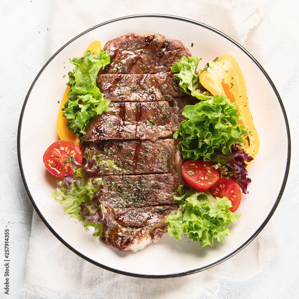 Grilled beef steak and fresh vegetables on plate