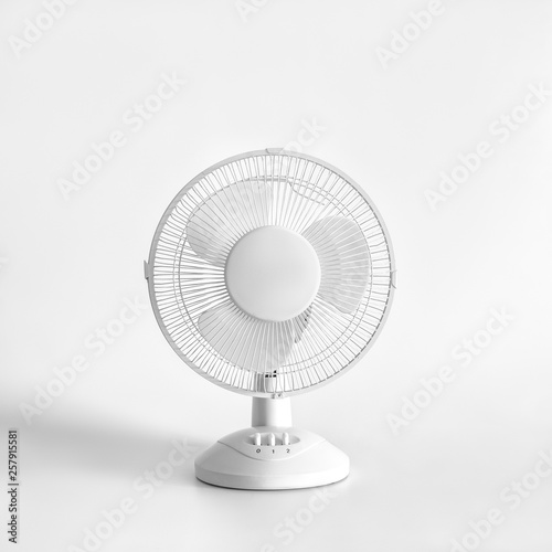 White desktop electric fan on light white background.
