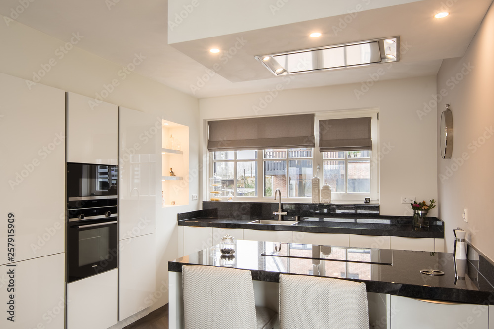 Modern luxury kitchen with light colors, kitchen island and granite table top in an architecture-built house Modern luxury kitchen with light colors, kitchen island and granite table top in an architecture-built house