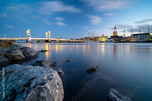 Nightfall with blue sky and long exposure above the old medieval city of Kampen in the Netherlands with its beautiful skyline