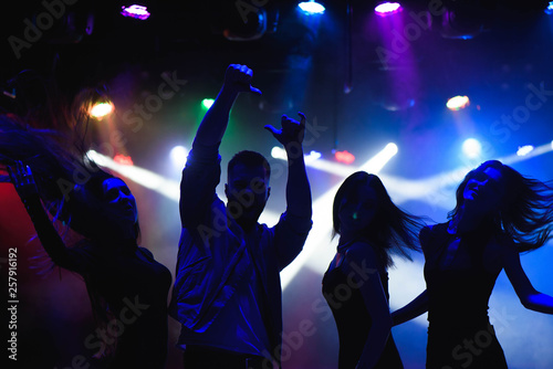 party, holidays, celebration, nightlife and people concept - group of happy friends dancing in night club photo