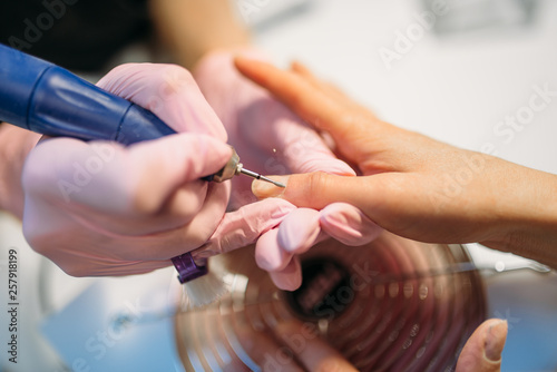 Beautician polishing nails of client, top view