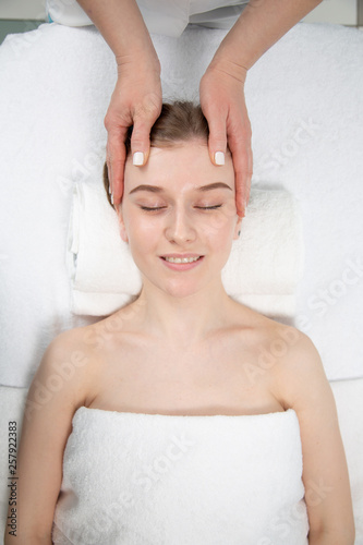 Relaxed woman receiving neck massage in wellness center