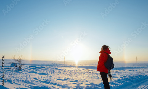 single Asian young girl looking at rainbow and sun in Arctic at Teriberka, Russia