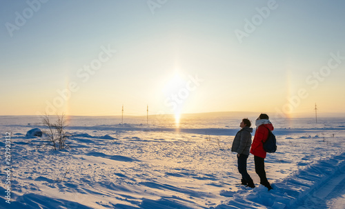Asian couple looking at rainbow and sun in Arctic at Teriberka, Russia photo