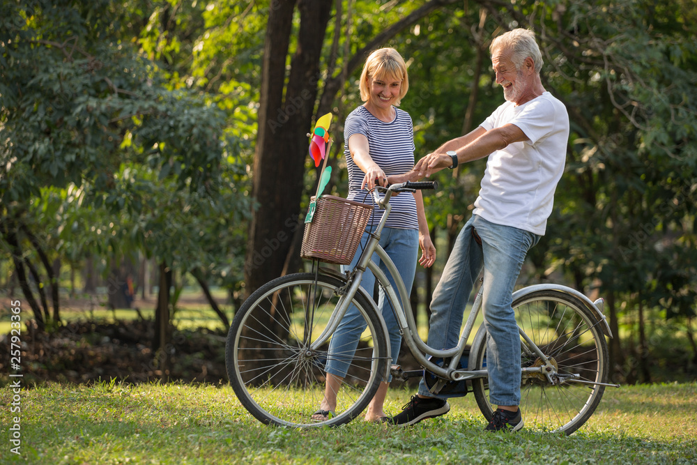 Happy senior couple relaxing at park walking with bike and talking together in morning time. old people in the autumn park . Elderly resting .mature relationships. family. romantic Happy senior couple relaxing at park walking with bike and talking together in morning time. old people in the autumn park . Elderly resting .mature relationships. family. romantic