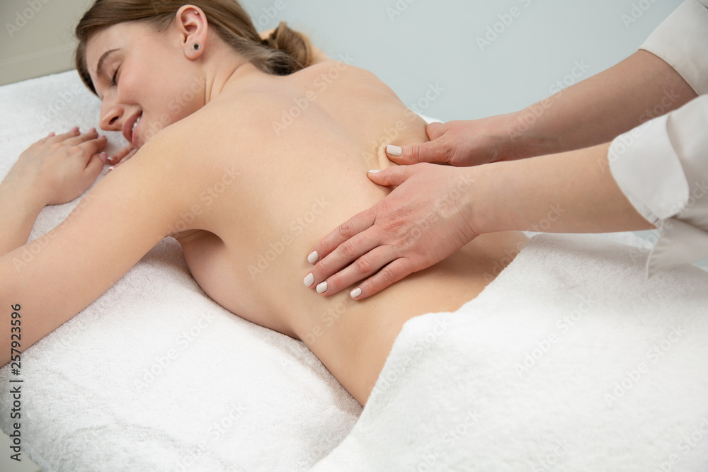 Young woman relaxing with hand massage at beauty spa.