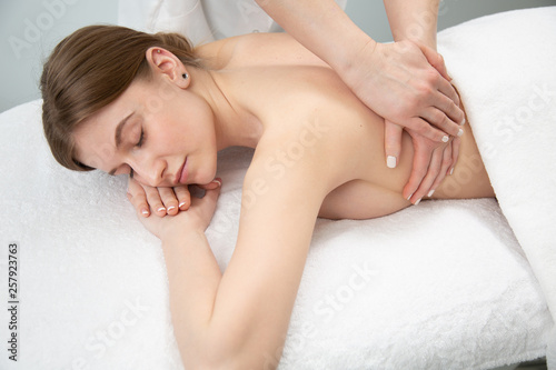 Young woman relaxing with hand massage at beauty spa.