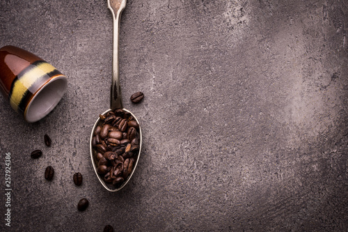 Tea and Coffee Beans in Rustic Spoons over Dark Stone Background