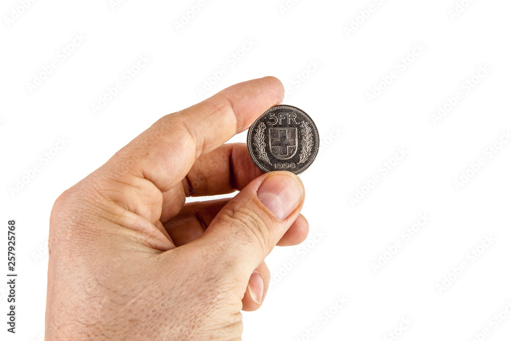 Male hand holding a five Swiss franc coin on a white isolated background. Male hand holding a five Swiss franc coin on a white isolated background.
