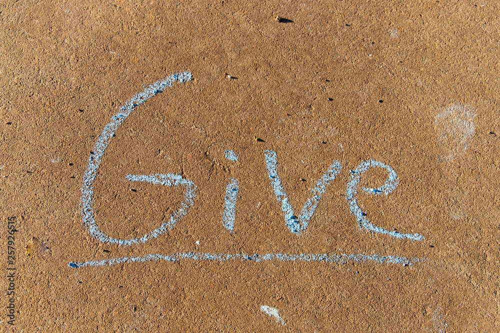 Fototapeta premium the word Give written with sidewalk chalk on gray concrete pavement background