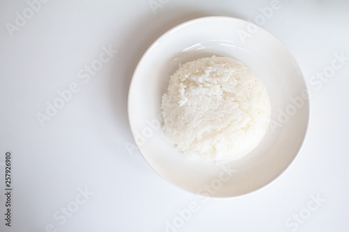 Rice garnished in white bowl on white desk.