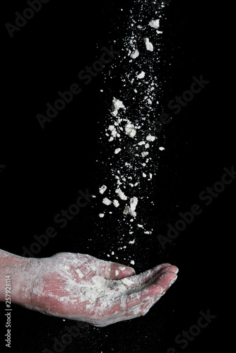 close up flour falling in mans hand  against black background 2