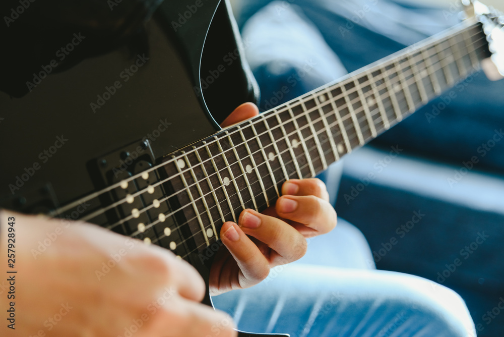 Fototapeta premium Placing the fingers on a guitar to play some notes by a professional guitarist.
