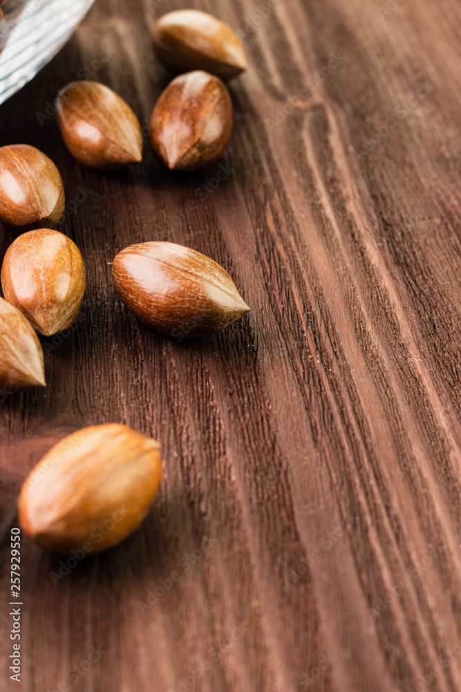 Pecan nuts in the shell on wooden background