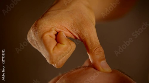 close-up of the thumb of the palm presses on the chakra at the base of the forehead in tantric practice