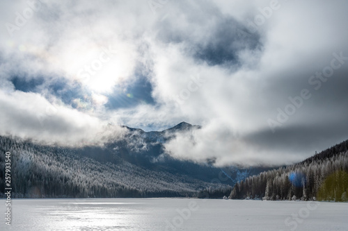 View of Stanton Lake with mountains against cloudy sky photo