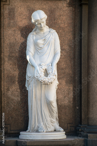 Statue aus Marmor einer Frau mit Kranz in einer Hand auf dem Dorotheenstädtischen Friedhof in Berlin
