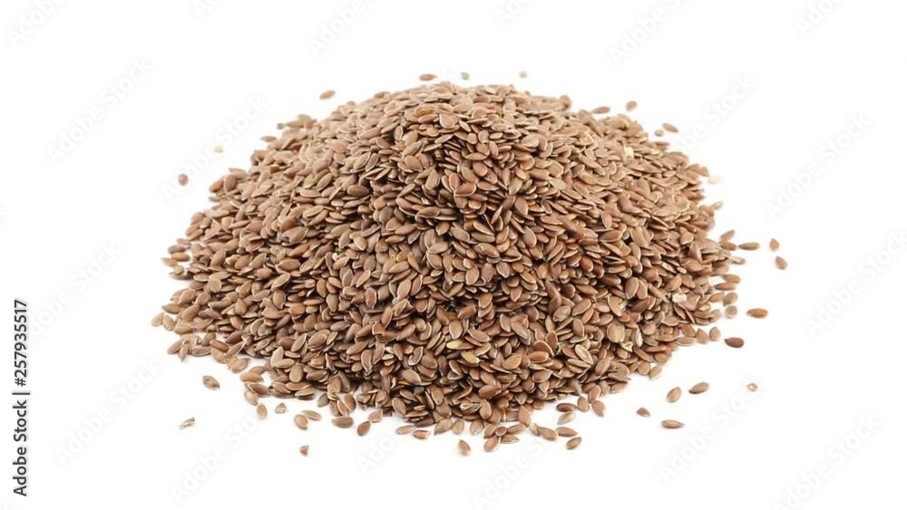 Heap of linseed or flaxseed grain rotating on white