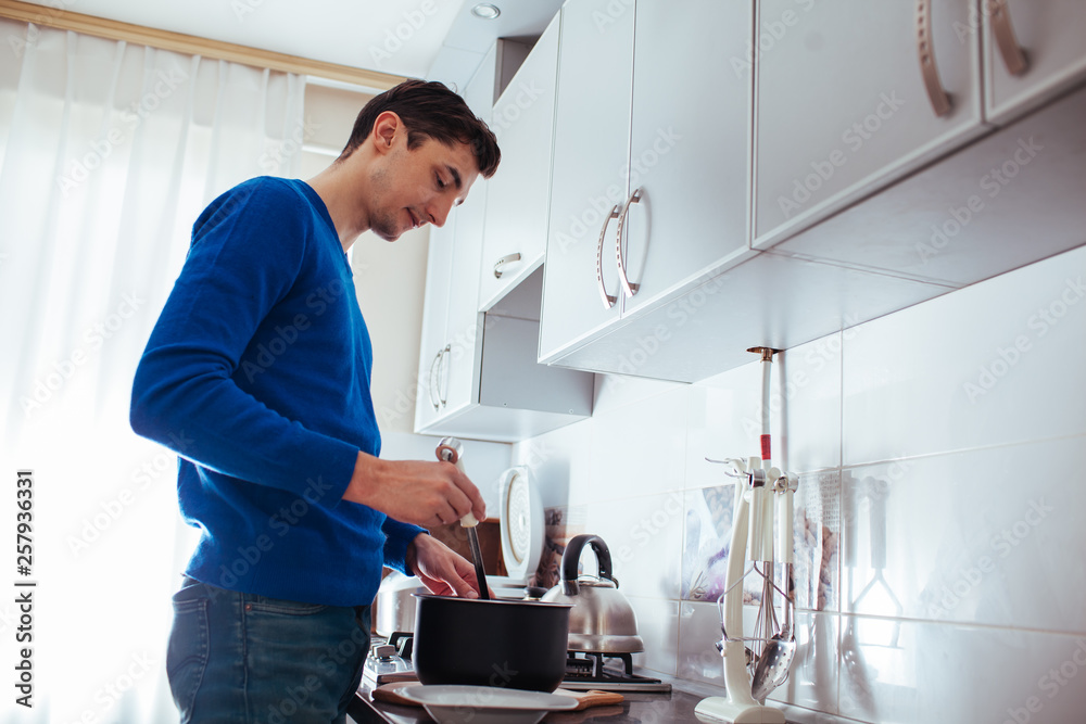 young man cooking in the kitchen young man cooking in the kitchen