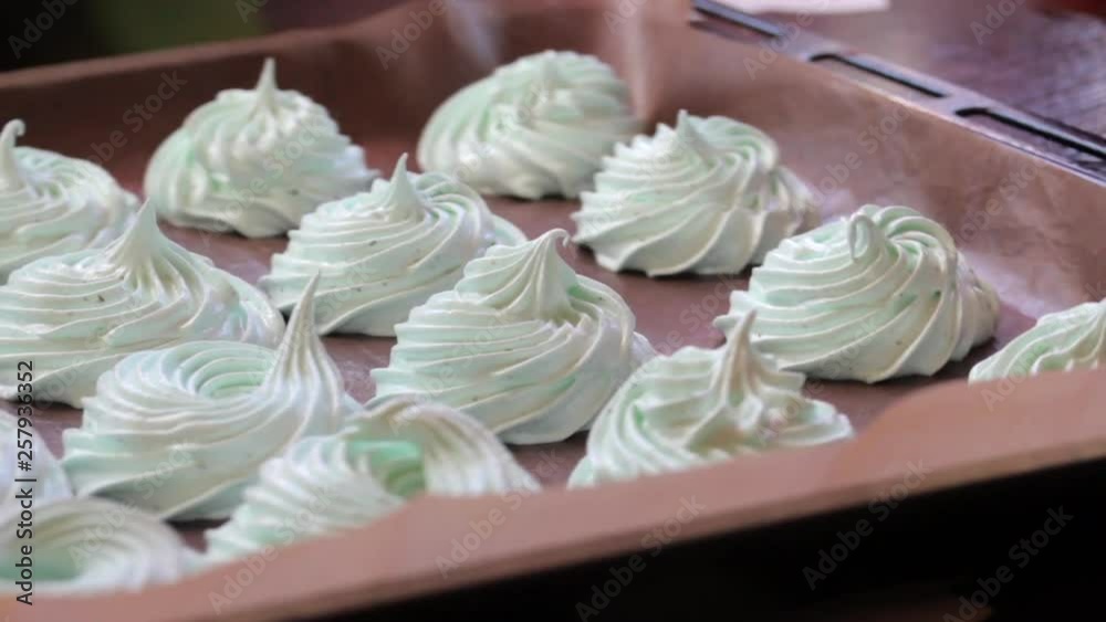 Freshly prepared marshmallows are laid on a flat surface to set. The baking tray rotates on a horizontal surface. Freshly prepared marshmallows are laid on a flat surface to set. The baking tray rotates on a horizontal surface.