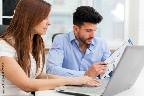 Two young business partners discussing plans or ideas at meeting