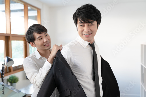 Young male couple getting dress in the changing room