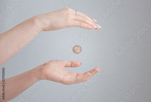 a coin falls from one hand to another, beautiful female hands, give alms, two euros
