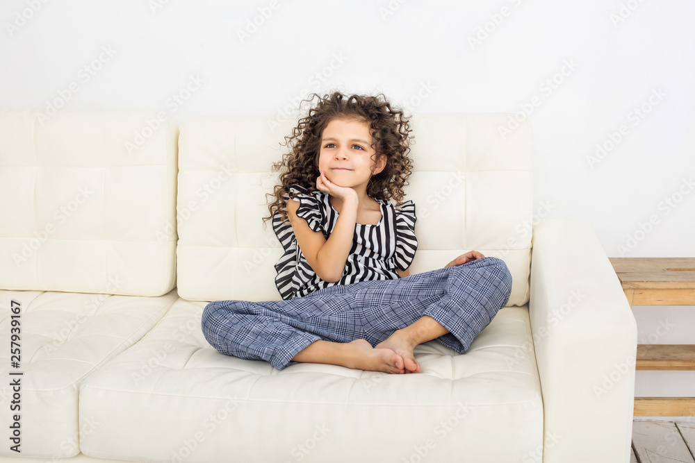 Child girl beautiful, cute cheerful and happy on the white sofa at home fashionable Child girl beautiful, cute cheerful and happy on the white sofa at home fashionable