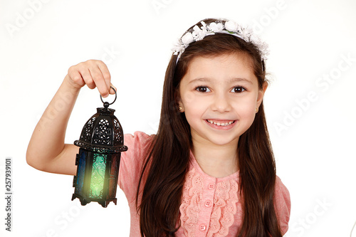 Happy young Muslim girl playing with lantern in Ramadan photo