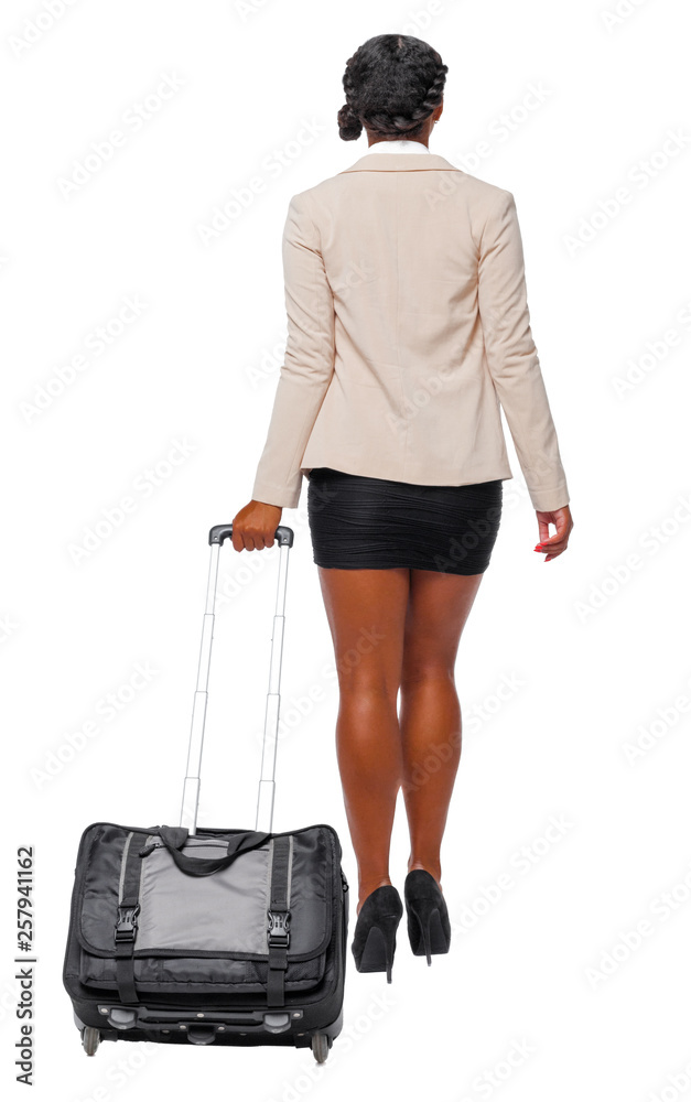 Back view of black African-American in formal attire walking with a suitcase. Back view of black African-American in formal attire walking with a suitcase.