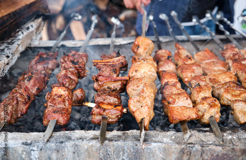 Grilled kebab cooking on metal skewer. Roasted meat cooked at barbecue. BBQ fresh beef meat chop slices. Traditional eastern dish, shish kebab.