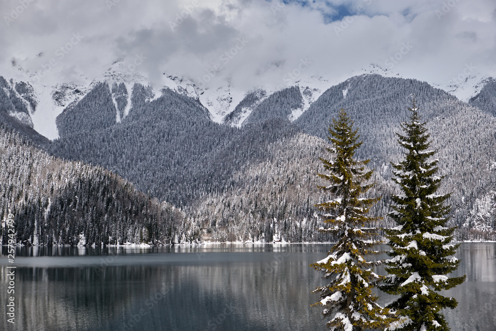 Beautiful mountain Lake Ritsa. Lake Ritsa in the Caucasus Mountains, in the north-western part of Abkhazia, Georgia, surrounded by mixed mountain forests and subalpine meadows. Snow in mountains Beautiful mountain Lake Ritsa. Lake Ritsa in the Caucasus Mountains, in the north-western part of Abkhazia, Georgia, surrounded by mixed mountain forests and subalpine meadows. Snow in mountains