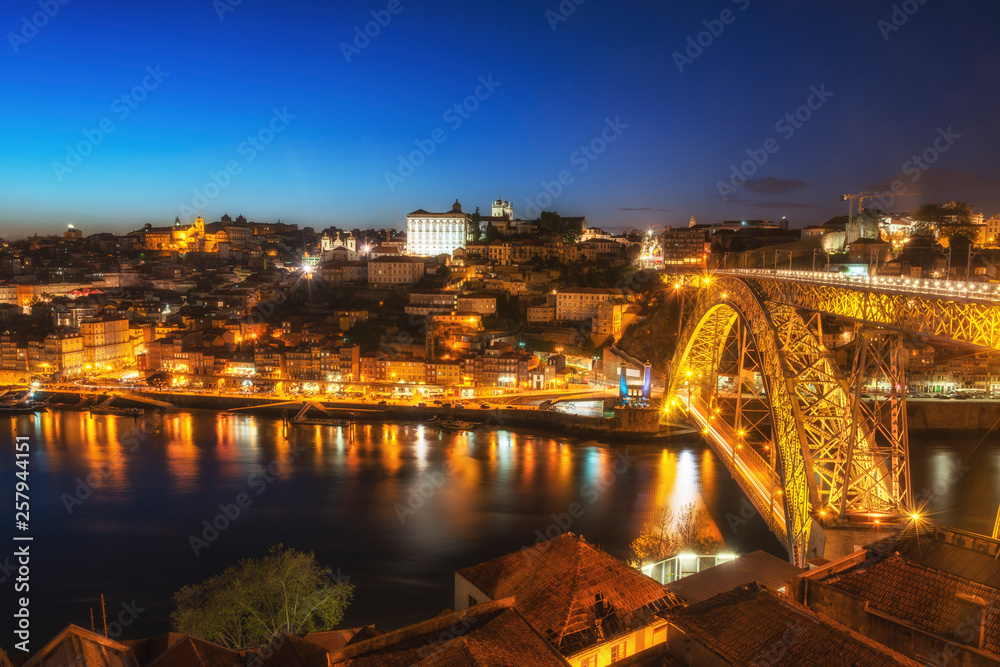 Night view of the Porto city center and Douro River with the bridge. Porto, Portugal.
