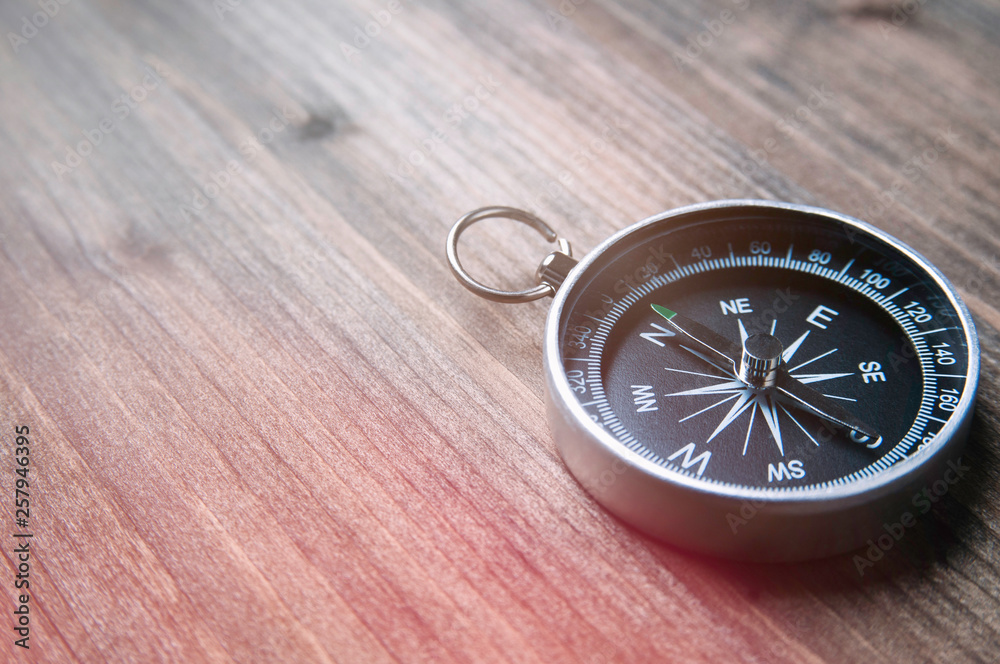 Old compass on a dark wooden background. Copy space for text or design Old compass on a dark wooden background. Copy space for text or design