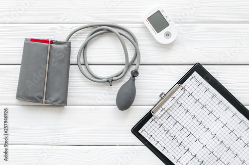 pulsimeter and cardiogram on the desk of the doctor for diagnostics of cardiac disease on white background top view photo