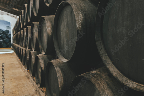 Barrels for whiskey or wine stacked in the cellar