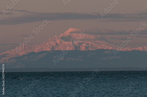 Mt Baker in pink evening alpenglow landscape background with Puget Sound foreground.