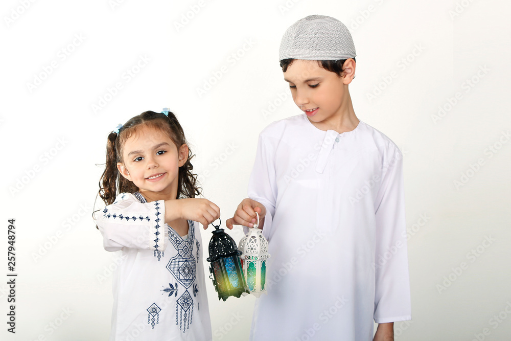 Happy Family in Ramadan - Cute brother and sister playing with Ramadan lanterns - celebrating the holy month of Ramadan Happy Family in Ramadan - Cute brother and sister playing with Ramadan lanterns - celebrating the holy month of Ramadan