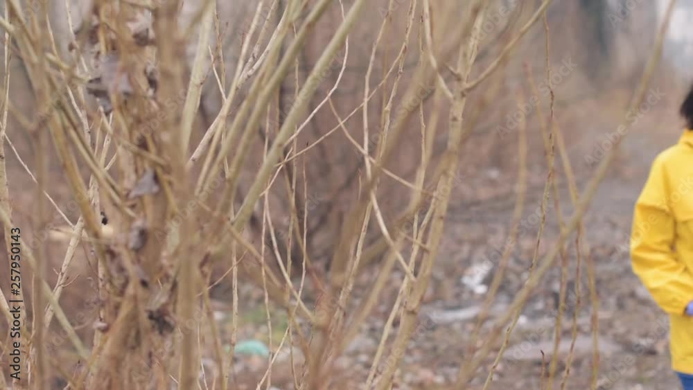 Woman in raincoat walking through meadow on a rainy day, worried and sad female on a gloomy afternoon, slow motion handheld footage Woman in raincoat walking through meadow on a rainy day, worried and sad female on a gloomy afternoon, slow motion handheld footage