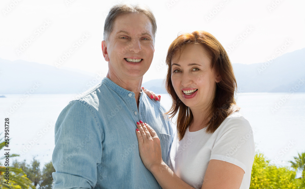 Summer family vacation. Happy middle aged couple having fun on travel holidays weekend. Sea and beach background. Copy space. Selective focus Summer family vacation. Happy middle aged couple having fun on travel holidays weekend. Sea and beach background. Copy space. Selective focus